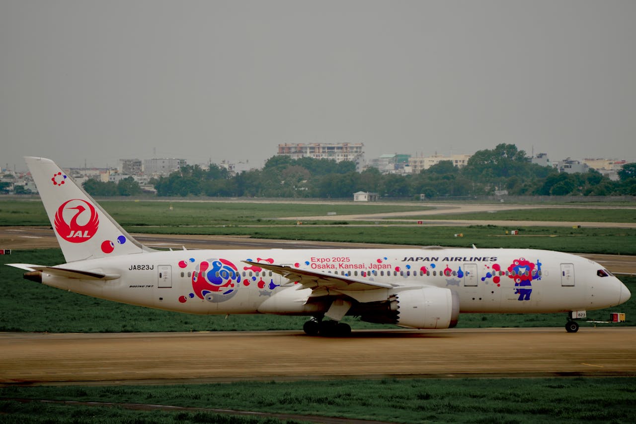 Japan Airlines aircraft taxiing with Expo 2025 Osaka Kansai design at airport.